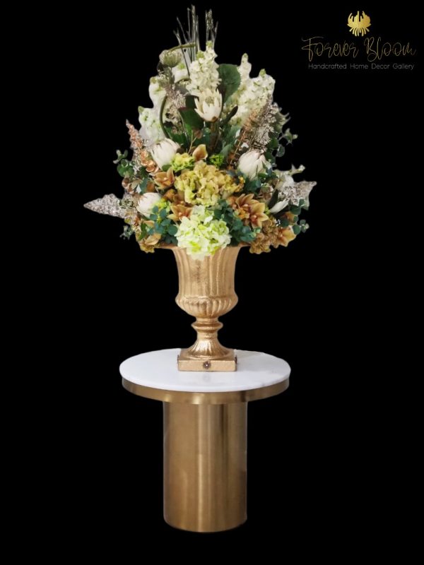“Amazing Grace” arrangement epitomizes this philosophy, featuring a harmonious mix of protea, roses, geraniums, calla lilies, and various luxury greenery, all accented with gold leaves. Nestled in a glamorous Victorian-style vase handpainted in rustic gold, “Amazing Grace” exudes sophistication and luxury, making it a standout piece in any home or venue.