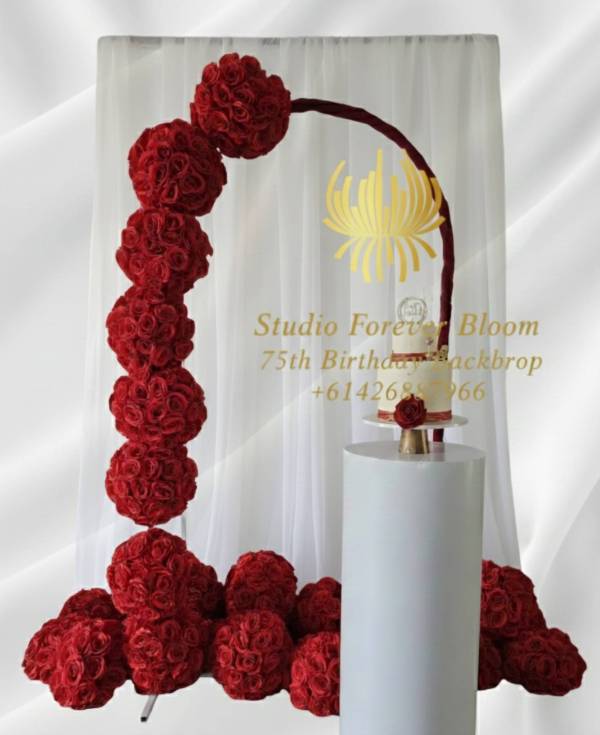 Luxury Red Rose Event Backdrop Hire – angled view of curved floral arch with half side red roses decorated