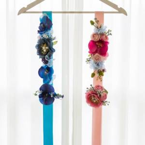 Blue and pink silk floral maternity sashes hanging on a wooden hanger by Studio Forever Bloom Melbourne.