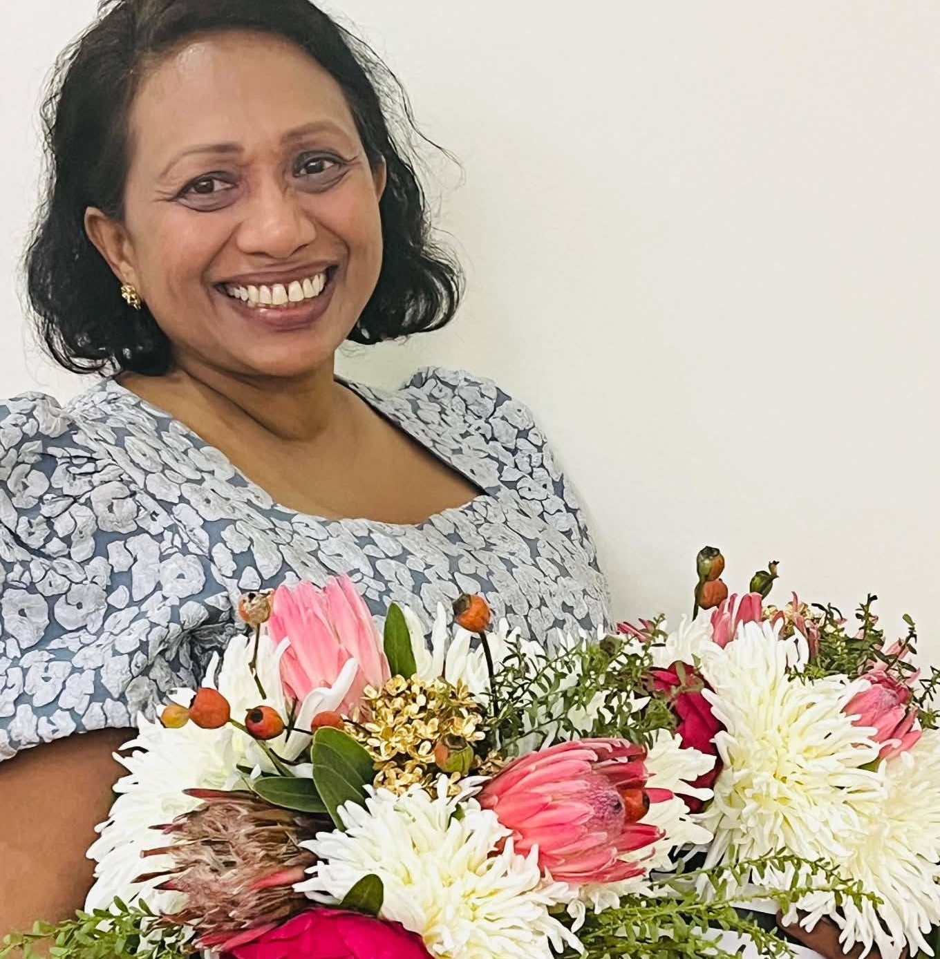 A group of four smiling elegantly dressed women standing behind a Studio Forever Bloom black and white striped hybrid floral centerpiece during an event on 11 July 2026 , Silk Floral Event Decor Melbourne
