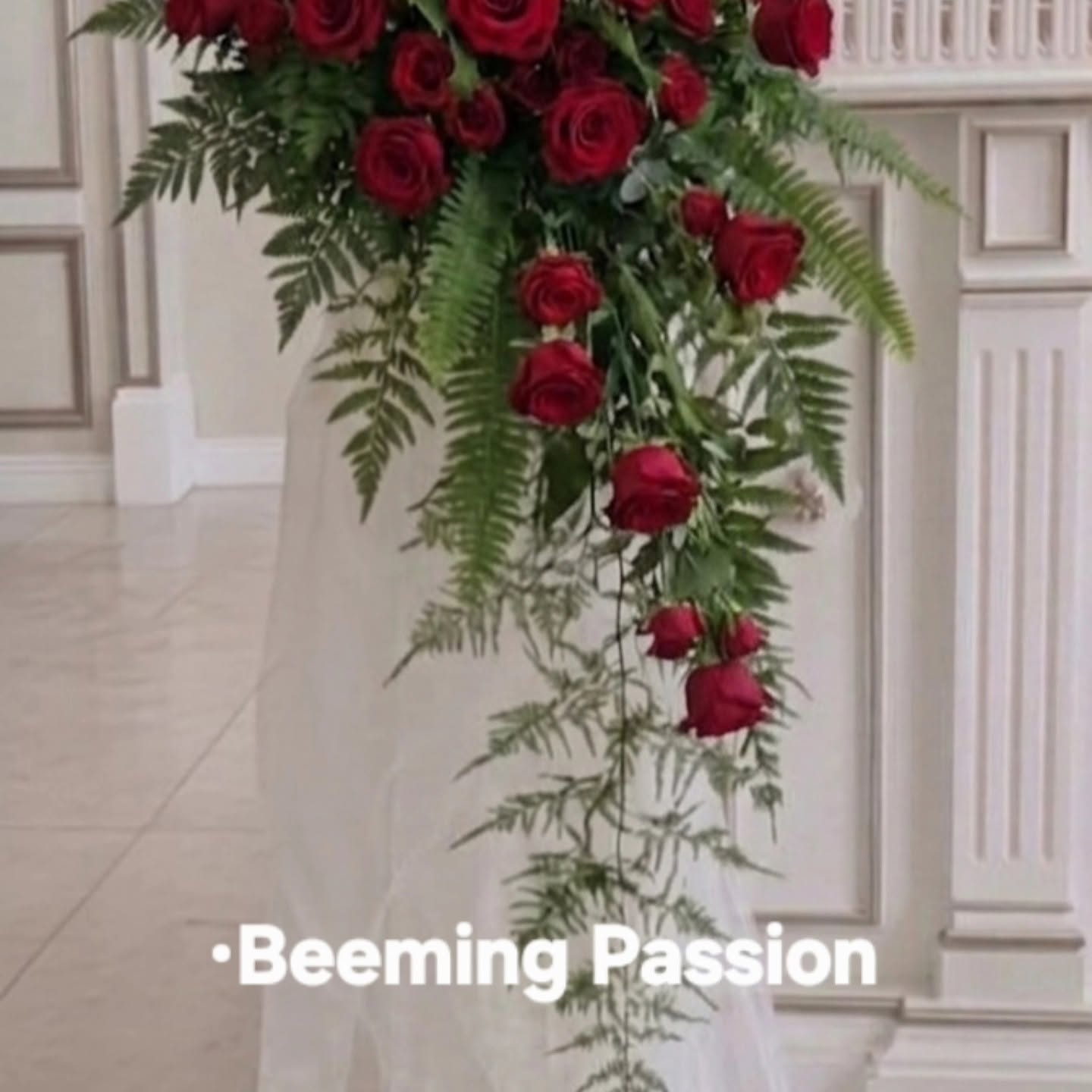 A cascading red rose 3D hybrid floral installation named Beeming Passion by Studio Forever Bloom.