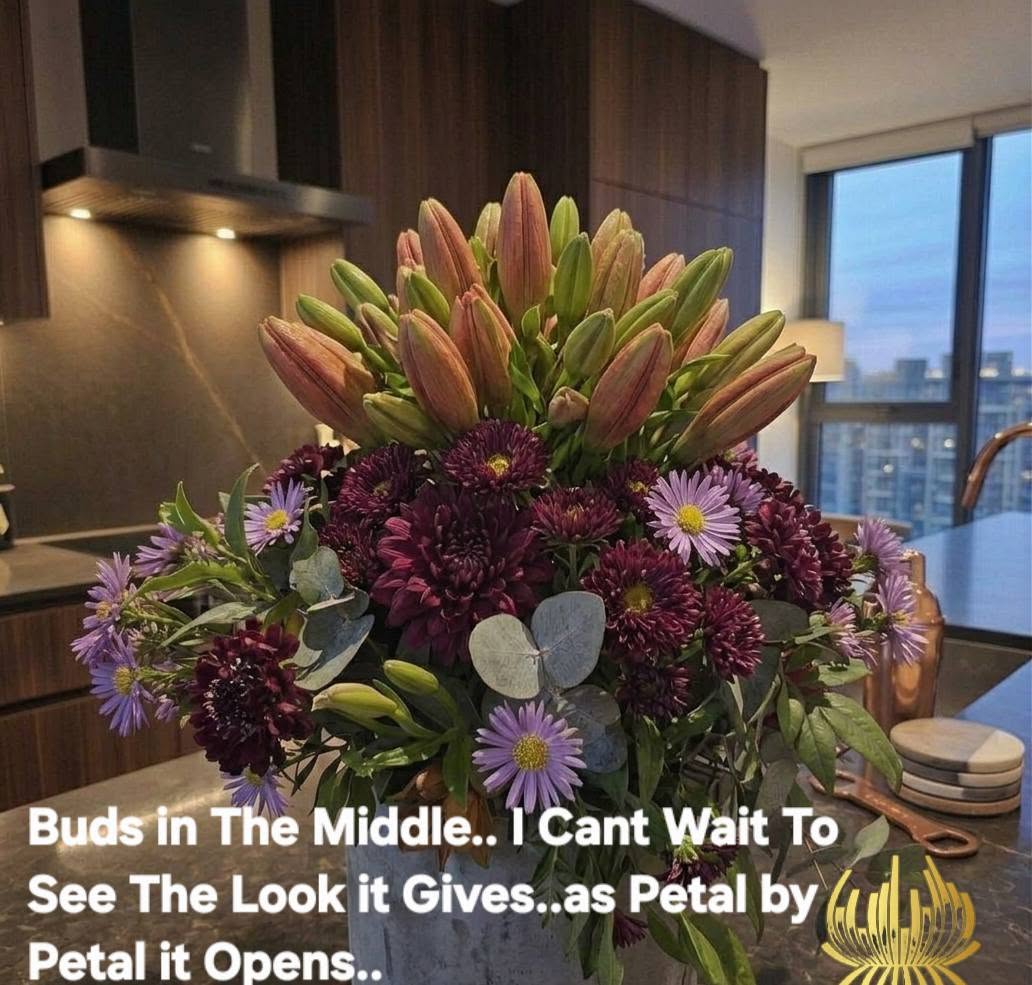 A luxury winter-themed floral display named WINTER LILIES Red Hybrid Arrangement V1 featuring large red lilies, dark burgundy blooms, and eucalyptus by Studio Forever Bloom.