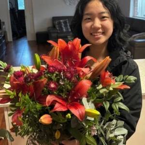Silk Floral Event Decor Melbourne A luxury winter-themed floral display named WINTER LILIES Red Hybrid Arrangement V1 featuring large red lilies, dark burgundy blooms, and eucalyptus by Studio Forever Bloom.