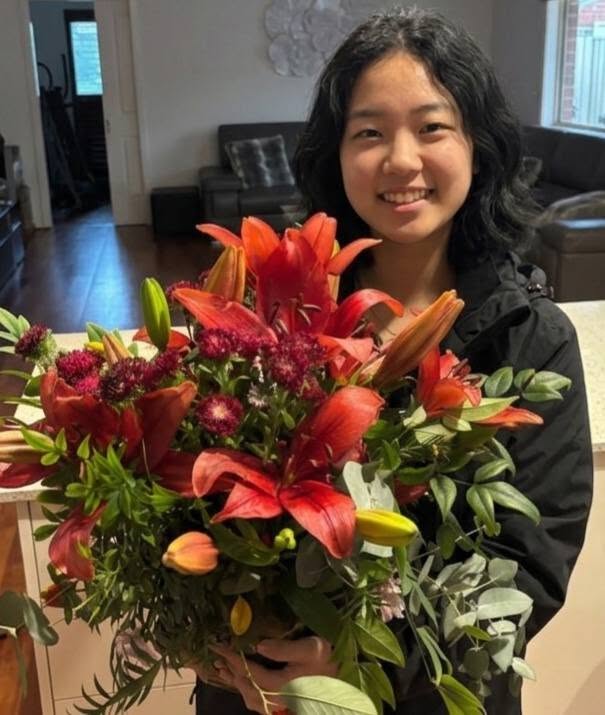 Silk Floral Event Decor Melbourne A luxury winter-themed floral display named WINTER LILIES Red Hybrid Arrangement V1 featuring large red lilies, dark burgundy blooms, and eucalyptus by Studio Forever Bloom.