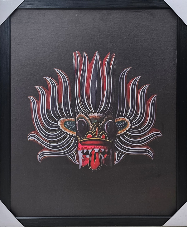 Framed 50x70 cm Traditional Sri Lankan Mask Art featuring intricate red and white patterns on a black background displayed on a wooden surface.